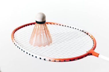 Badminton raketi ve beyaz arka planda mekik, yakın plan görüntüsü.