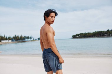 Aktif Asyalı Sporcu Sahilde Günbatımı Koşusu 'nun tadını çıkarıyor, Fitness Yaşam Tarzını Kucaklıyor