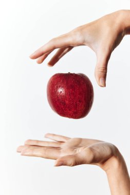 Bir elinde elma, diğer elinde dinleniyor ve iki elini de havaya kaldırıyor..