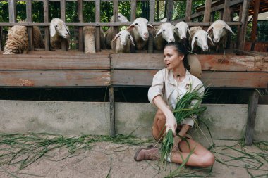 Önünde yeşil çimlerle yerde oturan bir kadın.