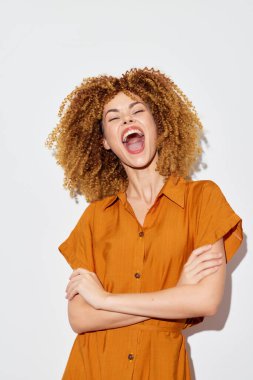 Joyful woman with expressive curly hair laughing heartily, wearing an orange dress Set against a clean white backdrop, this vibrant image radiates happiness, confidence, and carefree spirit, perfect clipart