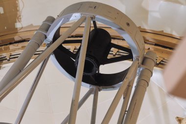 Bir gözlemevinde büyük bir teleskop onarım için geniş bir iskeleyle çevrili olarak yenileniyor..