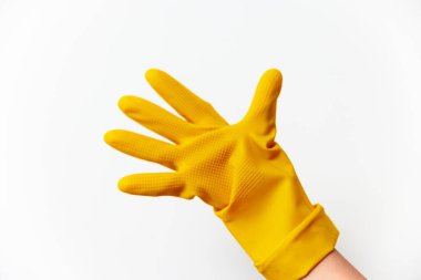 Elle tutulan sarı lastik eldiven beyaz arka planda fotokopi alanı ile. Temizlik ve ev işleri için izole nesne.