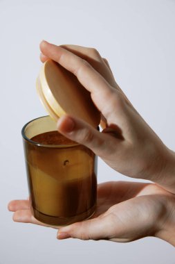 Beyaz arka planda ahşap kapaklı el ele tutuşmuş mum..