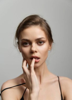 Uzun saçlı, büyüleyici gözleri olan, zarafet ve zarafetle dolup taşan, sessiz, gri bir arka plana kurulmuş dalgın bir kadın manken. Güzellik ve moda temaları için ideal.