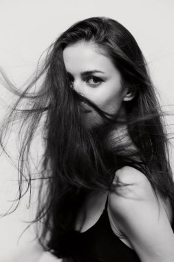 Kendine güvenen genç bir kadının çarpıcı portresi. Hareketli uzun saçları var. Güzellik ve zarafet sergiliyor. Moda ve yaşam tarzı tasvirleri için ideal.