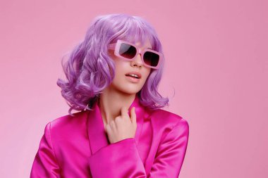 Mor saçlı kadın, güneş gözlüğü, pembe elbise, pembe arka plan.