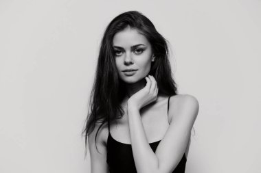 Çekici bir siyah beyaz portre genç bir kadının sakin ifadesini sergiliyor, güzelliğini ve özgüvenini vurguluyor, güzellik ve moda kavramları için mükemmel..