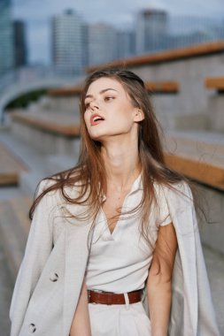 Kendine güvenen bir iş kadınının sakin portresi, şık giyinmiş, profesyonelliği ve zarafeti vurguluyor. Kentsel ufuk çizgisi modern kişiliğini geliştiriyor.