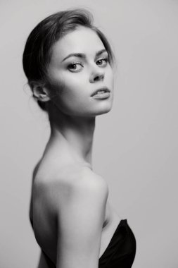 Sofistike ve dengeli, yumuşak bir ifade ve minimalist estetik ile genç bir kadının çarpıcı siyah beyaz portresi. Güzelliği ve basitliği vurgular.