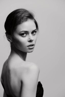 Şık bir model güzelliğini ve zarafetini zarif bir şekilde saçlarıyla sergileyerek minimalist bir ortamda kendine güveni yayıyor. Tek renkli fotoğrafçılık duyguları vurguluyor.