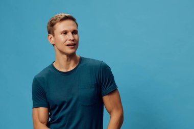 Tebessüm eden beyaz bir adam yeşil tişört giyer düşünceli iyimser bir stil izole edilmiş dijital göçebe uzaktan kumandalı iş yaşam tarzı konsepti giyer.