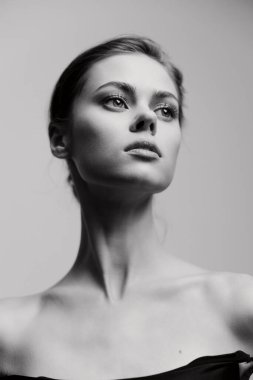 Zarif özelliklerini ve minimalist tarzını vurgulayan iç gözlemci bir bakışla çarpıcı siyah beyaz bir kadın portresi. Güzellik ve moda temaları için mükemmel.