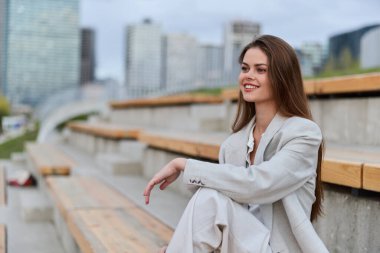 Açık tribünde oturan, kendine güveni ve profesyonelliği yüksek, şirket, iş ve yetki temaları için mükemmel bir iş kadını..