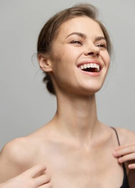 Neşeli bir kadın, mutlu bir gülümsemeyle bir anlık mutluluğun tadını çıkarıyor, doğal güzelliği ve kendine güveni sergiliyor, sağlık ve pozitiflik temaları için mükemmel..