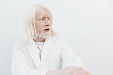 Uzun beyaz saçlı, beyaz sakallı, beyaz önlüklü yaşlı bir adamın şaşırtıcı portresi parlak, minimalist beyaz arka plan, çarpıcı ve ilginç bir görünüm yaratıyor.