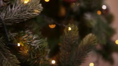 Klasik yeni yıl ağacı, gümüş, beyaz, pembe süsleme oyuncakları, top ve çözünmüş çelenk ışıklarıyla süslenmiş. Modern klasik tatil tasarımı. Evde Noel arifesi