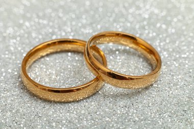 Will you marry me. Two golden wedding rings on silver glitter background. Engagement marriage proposal wedding concept. St. Valentines Day postcard. Banner on valentines day. Copy space