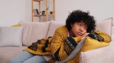 African american sad thoughtful girl at home. Young african woman feels depressed offended lonely upset suffers from abuse harassment heartbreak. Grieving violence victim has psychological problem