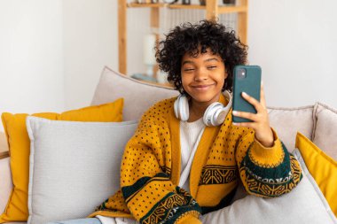 African american girl holding smartphone having video chat. Female blogger chatting with best friends in social network. Young woman having virtual meeting online chat video call at home