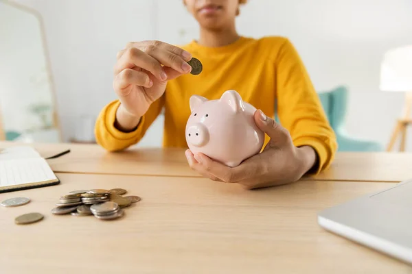 stock image Saving money investment for future. African american girl holding pink piggy bank and putting money coin. Saving investment budget business wealth retirement financial money banking concept