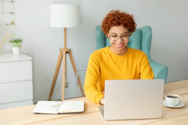 African american girl using laptop at home office looking at screen typing chatting reading writing email. Young woman having virtual meeting online chat video call conference. Work learning from home