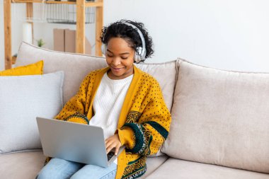 African american girl using laptop at home office looking at screen typing chatting reading writing email. Young woman having virtual meeting online chat video call conference. Work learning from home