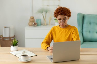 African american girl using laptop at home office looking at screen typing chatting reading writing email. Young woman having virtual meeting online chat video call conference. Work learning from home