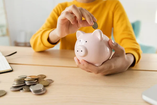 Saving money investment for future. African american girl holding pink piggy bank and putting money coin. Saving investment budget business wealth retirement financial money banking concept