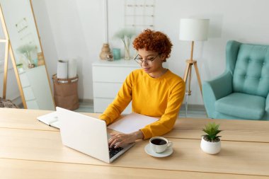 African american girl using laptop at home office looking at screen typing chatting reading writing email. Young woman having virtual meeting online chat video call conference. Work learning from home