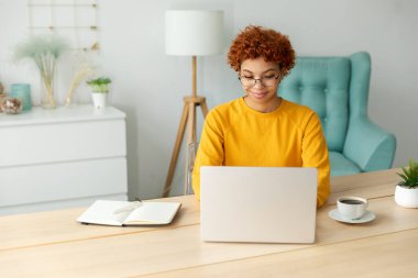 African american girl using laptop at home office looking at screen typing chatting reading writing email. Young woman having virtual meeting online chat video call conference. Work learning from home