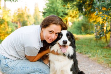 Genç ve çekici bir kadın yaz sezonunda sevimli köpek çoban köpeğiyle oynuyor. Öpüşen kız kucaklaşan köpek arkadaşı. Hayvan bakımı ve hayvan bakımı kavramı
