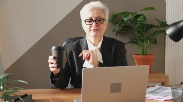 中年妇女领导在网上会议上与团队讨论 上了年纪的商界女性在办公室用笔记本电脑谈论视频通话 讨论项目构想 — 图库视频影像