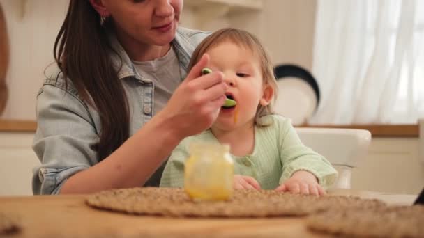 Familia Feliz Casa Madre Alimentando Bebé Con Cuchara Cocina Niño — Vídeo de stock