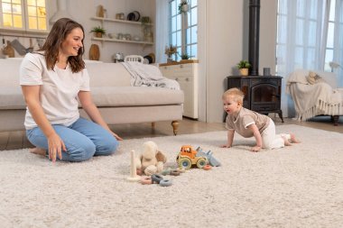 Evde mutlu bir aile. Anne ve bebek evde oyuncaklarla oynuyor. Küçük çocuk ve bebek bakıcısı birlikte eğleniyorlar. Genç kadın, anne, çocuk oturma odasında dinleniyor.