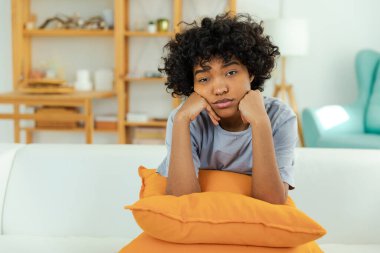 Afro-Amerikan üzgün, düşünceli kız evde. Genç Afrikalı bir kadın, tacize uğradığı için üzgün, yalnız ve üzgün hissediyor. Yas tutan şiddet mağdurunun psikolojik sorunu var