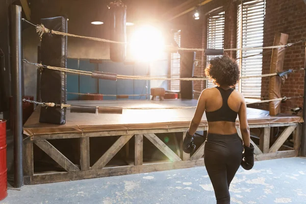 Women self defense. African woman fighter preparing for competition fight going to boxing ring. Strong girl ready for fight active exercise sparring workout training. Training day in boxing gym