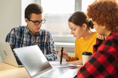 Odaklanmış kadın takım lideri, ofisteki ortaklarla iş görüşmeleri ile ilgili finansal istatistikleri tartışıyor. Bayan patron, genç iş kadını. Çeşitli şirket profesyonel takımı.