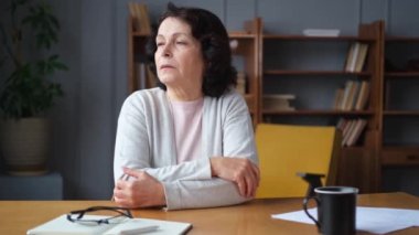Üzgün, hasta, yalnız, yaşlı bir kadın evde yalnız oturuyor. Mutsuz, olgun bir büyükanne yas tutuyor. Ölümüne kötü haber. Stresli yaşlı kadın yalnızlıktan muzdarip.