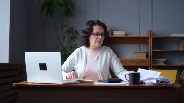 Wanita Tua Paruh Baya Duduk Dengan Laptop Dan Dokumen Kertas — Stok Video