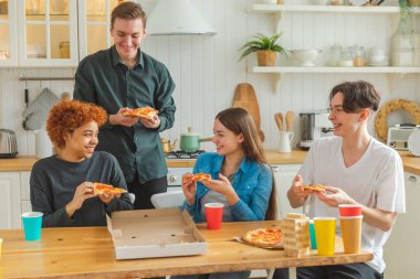 Ev partisi. Ev partisi için pizza sipariş eden aşırı neşeli arkadaşlar. Mutlu grup karışık ırk gençleri birlikte boş zaman geçirmenin keyfini çıkarıyorlar birlikte eğleniyorlar gülüyorlar şakalaşarak iletişim kuruyorlar