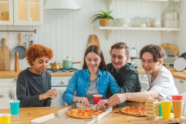 Ev partisi. Ev partisi için pizza sipariş eden aşırı neşeli arkadaşlar. Mutlu grup karışık ırk gençleri birlikte boş zaman geçirmenin keyfini çıkarıyorlar birlikte eğleniyorlar gülüyorlar şakalaşarak iletişim kuruyorlar