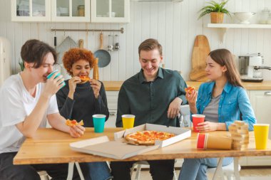 Ev partisi. Ev partisi için pizza sipariş eden aşırı neşeli arkadaşlar. Mutlu grup karışık ırk gençleri birlikte boş zaman geçirmenin keyfini çıkarıyorlar birlikte eğleniyorlar gülüyorlar şakalaşarak iletişim kuruyorlar