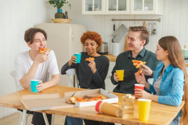Ev partisi. Ev partisi için pizza sipariş eden aşırı neşeli arkadaşlar. Mutlu grup karışık ırk gençleri birlikte boş zaman geçirmenin keyfini çıkarıyorlar birlikte eğleniyorlar gülüyorlar şakalaşarak iletişim kuruyorlar