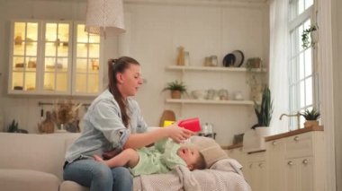 Evde mutlu bir aile. Anne ve bebek evdeki kanepede oynuyorlar. Küçük çocuk ve bebek bakıcısı birlikte eğleniyorlar. Genç kadın anne, küçük kız oturma odasında dinleniyor.