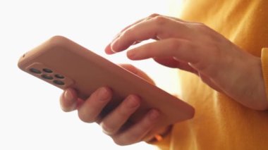 Cep telefonu tutan kadın uygulamayı kullanarak ekran parşömen sayfasına dokunuyor. Akıllı telefon cep telefonu aygıtı ellerinde. İnternet haber içeriği uygulamaları cep telefonu bağımlılığı kavramı