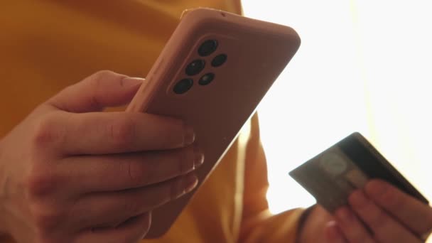 女人们手握智能手机在网上购物 用信用卡付款 在网上购物的女孩输入信用卡的细节 网上购物电子商务交付服务 — 图库视频影像