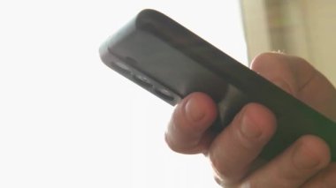 Cep telefonu tutan adam uygulamayı kullanarak ekran kaydırma sayfasına dokunuyor. Akıllı telefon cep telefonu aygıtı ellerinde. İnternet haber içeriği uygulamaları cep telefonu bağımlılığı kavramı