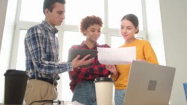 Takım çalışması genç profesyonel takım konsepti. Ofis toplantısında işbirliği yapan çok ırklı iş arkadaşları çok mutlu. Çeşitli meslektaşlar proje fikirlerini düzenleme belgelerini tartışıyor