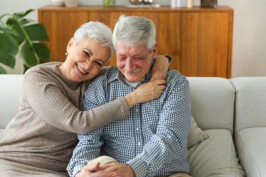 Yetişkin bir çiftin evde kucaklaşması. Orta yaşlı karı ve koca şefkatle kucaklaşıp tatlı bir bağ kurmanın tadını çıkarıyorlar. Büyükannem ve büyükbabam birlikte. Aile zamanı sevgi ve ilgi